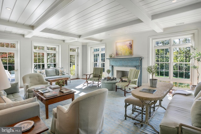 sunroom featuring beamed ceiling, wood ceiling, and a high end fireplace