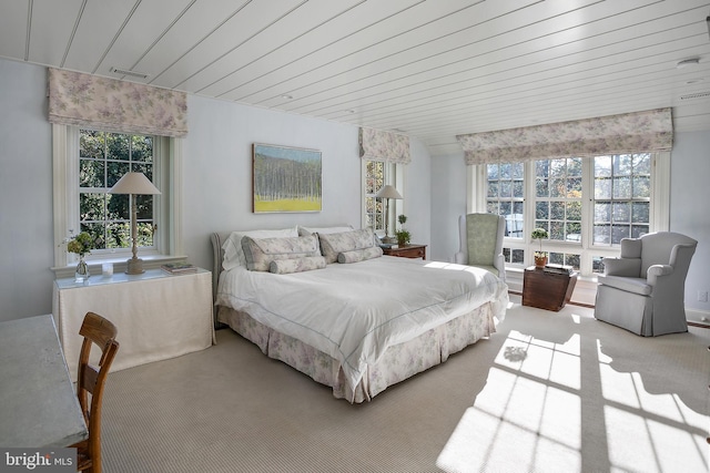 bedroom featuring multiple windows and light colored carpet