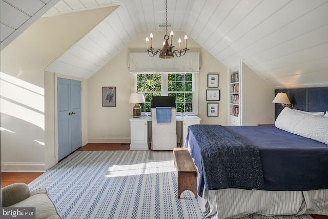 bedroom featuring lofted ceiling, hardwood / wood-style floors, and a notable chandelier