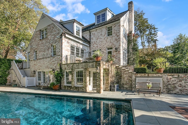 back of house featuring a fenced in pool, french doors, and a patio