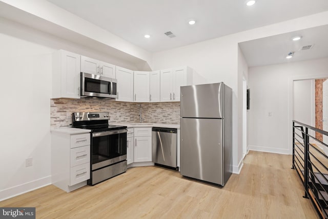 kitchen featuring appliances with stainless steel finishes, tasteful backsplash, and light hardwood / wood-style floors