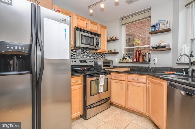 kitchen featuring stainless steel appliances, tasteful backsplash, sink, and light brown cabinetry