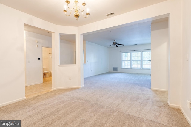 unfurnished room featuring ceiling fan with notable chandelier and light carpet