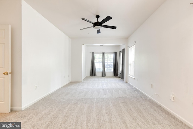 carpeted spare room featuring ceiling fan