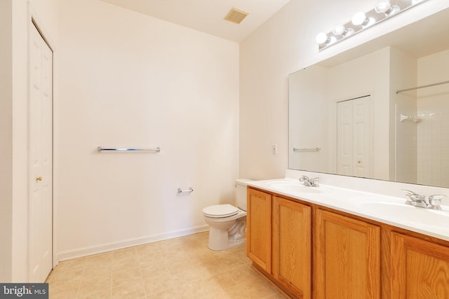 bathroom featuring dual vanity, toilet, and tile patterned floors