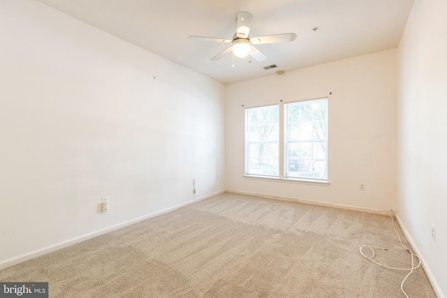 spare room with ceiling fan and light carpet