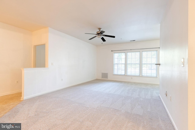 spare room featuring ceiling fan and light carpet