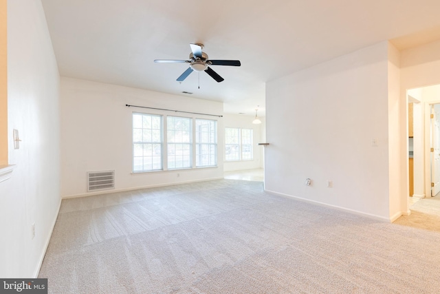 empty room with ceiling fan and light carpet