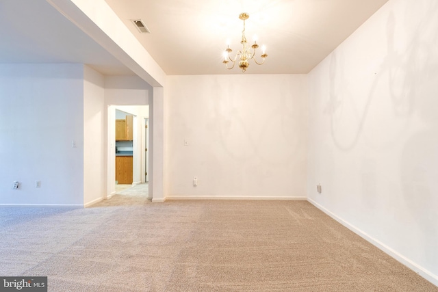 unfurnished room with carpet floors and a notable chandelier