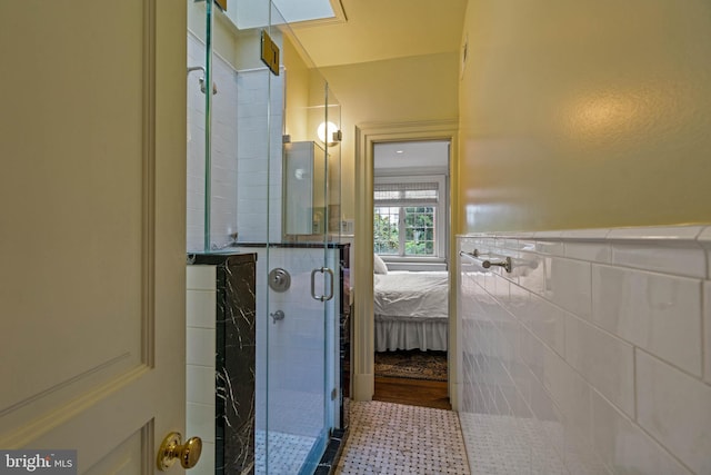 bathroom with a stall shower, ensuite bath, tile walls, and wainscoting