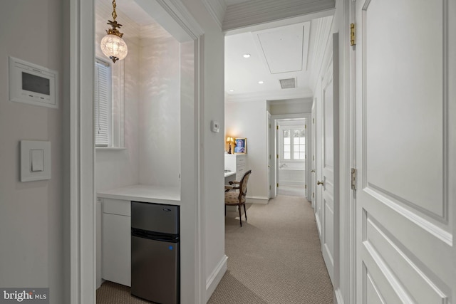 hall with recessed lighting, visible vents, attic access, ornamental molding, and light carpet