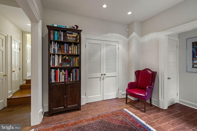 sitting room featuring wood tiled floor, baseboards, and recessed lighting