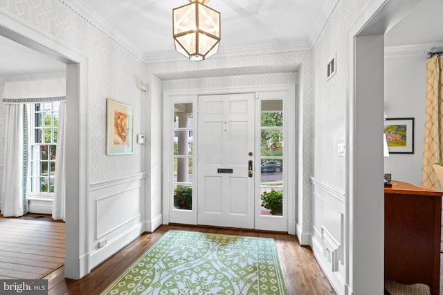 entrance foyer with crown molding, a healthy amount of sunlight, and wood-type flooring