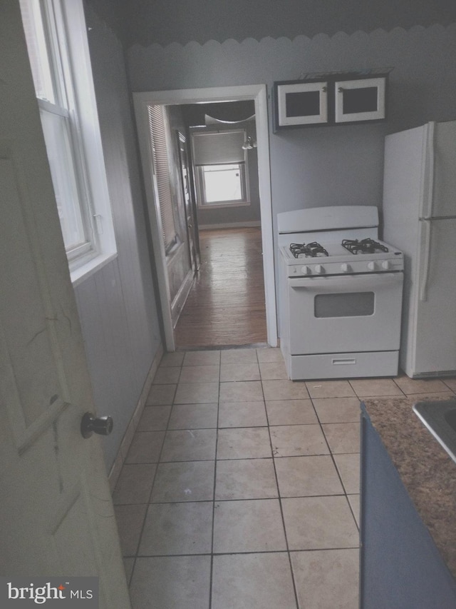 kitchen featuring light wood-type flooring, white appliances, and white cabinets