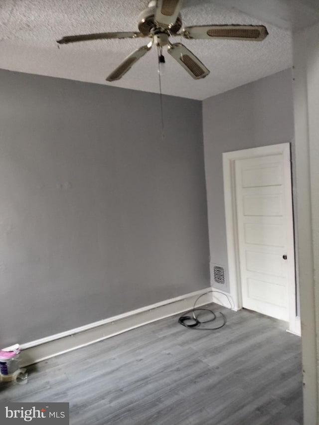 spare room featuring ceiling fan, a textured ceiling, and wood-type flooring