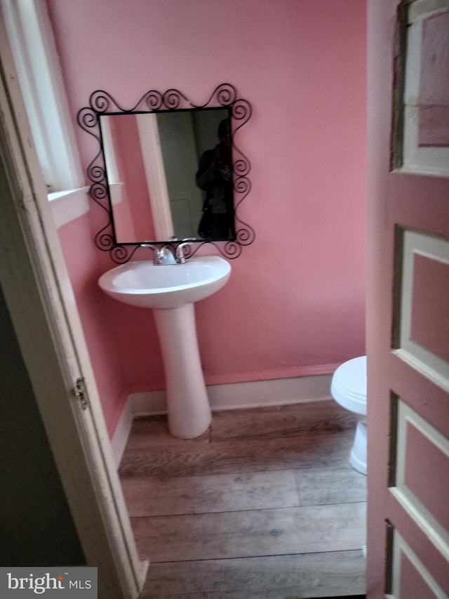 bathroom with hardwood / wood-style floors and toilet