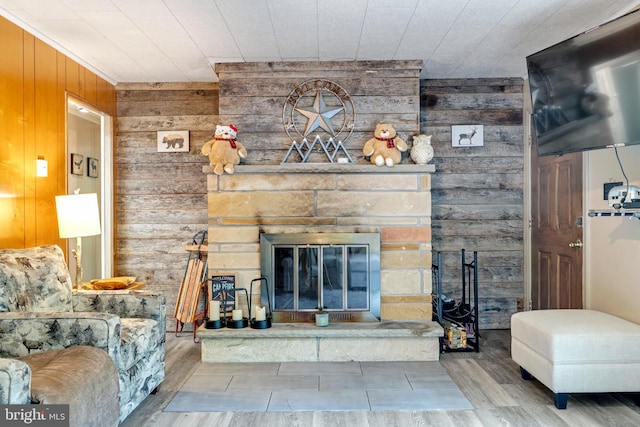 living room featuring a fireplace and wooden walls