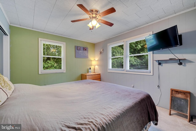 carpeted bedroom with crown molding and ceiling fan