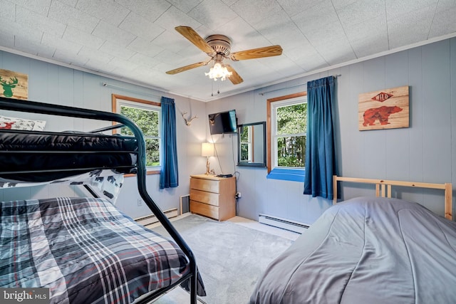 carpeted bedroom with a baseboard radiator, crown molding, ceiling fan, and multiple windows