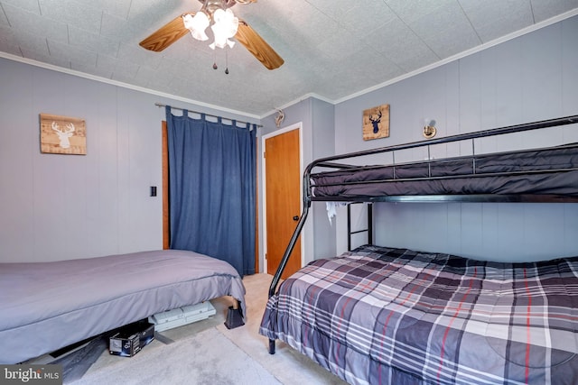 carpeted bedroom with ceiling fan and ornamental molding