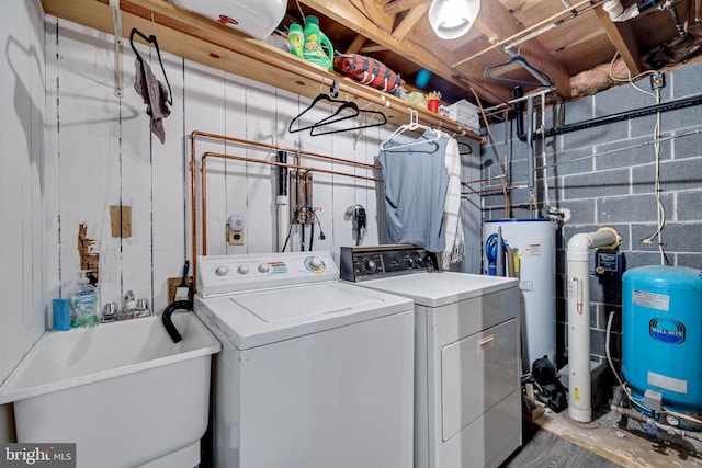 laundry room featuring independent washer and dryer, gas water heater, and sink