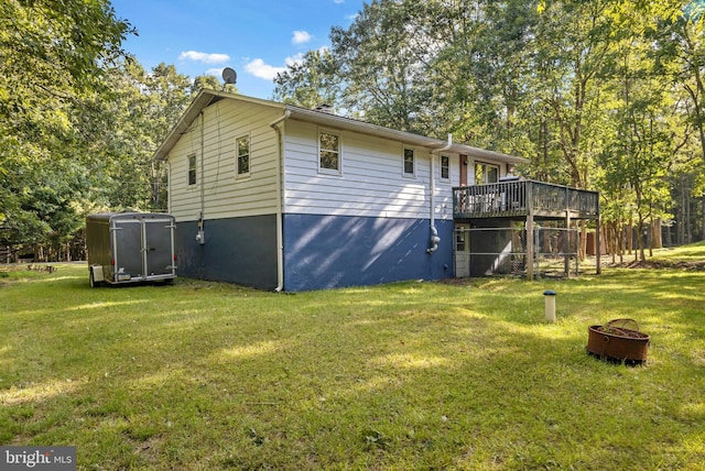 view of side of property with a deck and a lawn