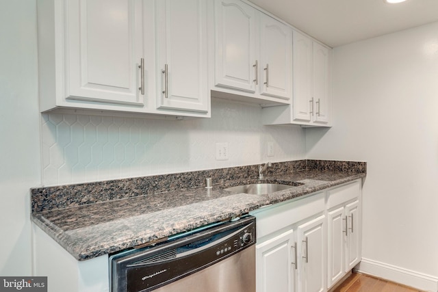 kitchen with a sink, white cabinetry, dark stone counters, and dishwasher