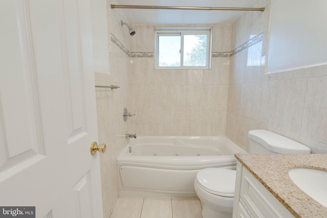 full bath with tile walls, a combined bath / shower with jetted tub, toilet, vanity, and tile patterned floors