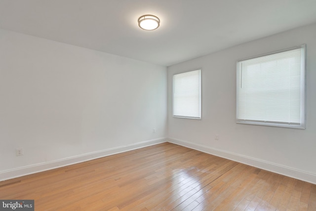 unfurnished room featuring light wood-style flooring and baseboards