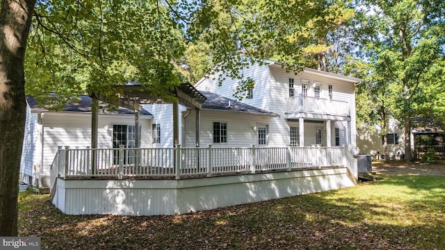 rear view of house featuring a yard, a wooden deck, and central AC unit