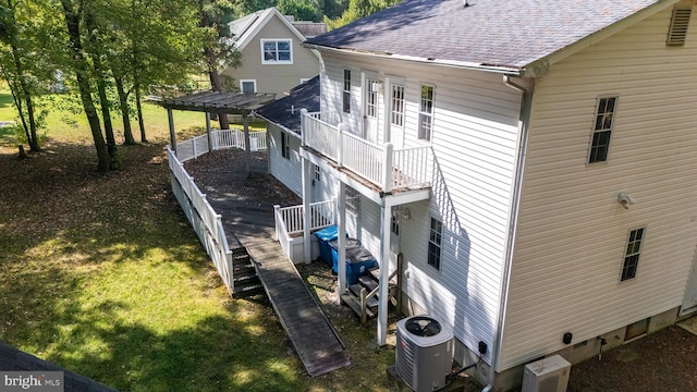 exterior space with ac unit, central air condition unit, and a lawn