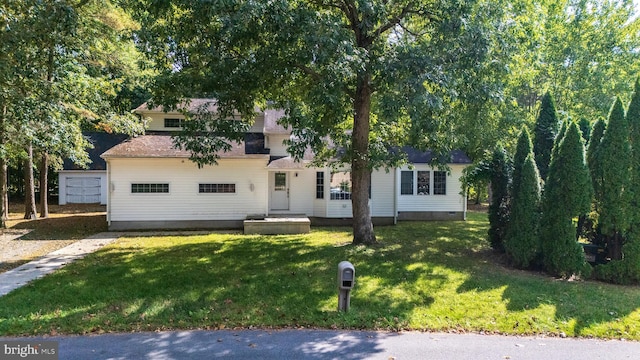 view of front of property featuring a shed and a front lawn