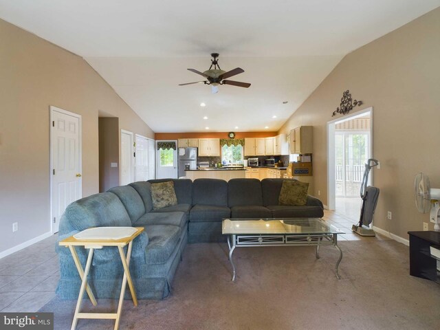 tiled living room featuring ceiling fan and vaulted ceiling