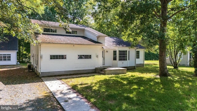 rear view of property featuring a yard