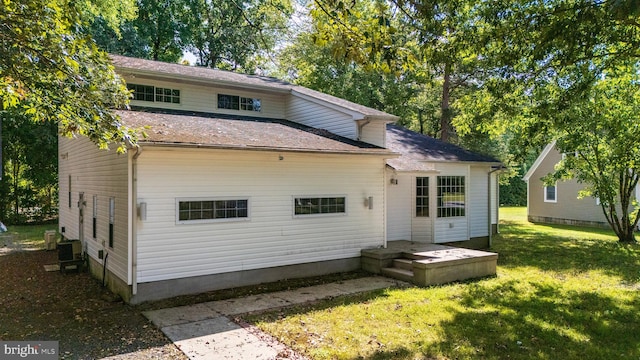 back of property with a yard and central AC unit