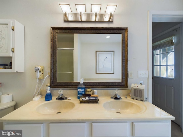 bathroom with toilet, a shower with door, and vanity