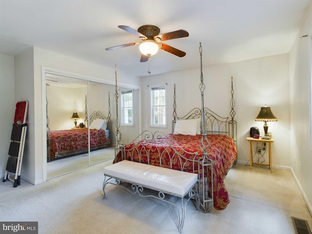 carpeted bedroom featuring ceiling fan and a closet