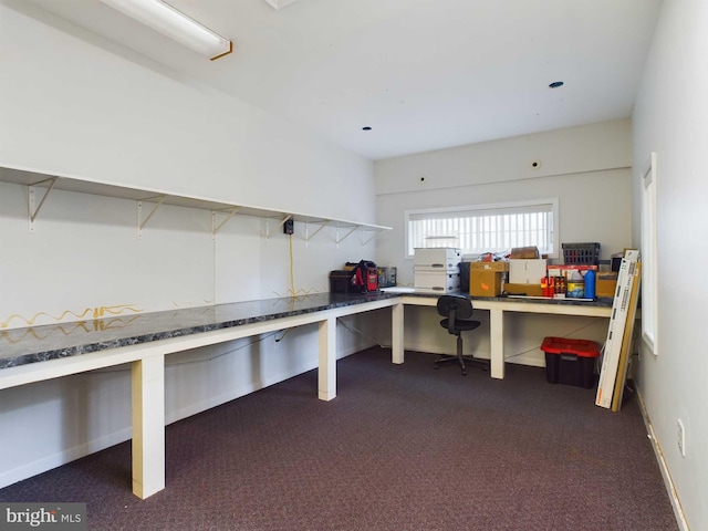 interior space featuring built in desk and dark carpet