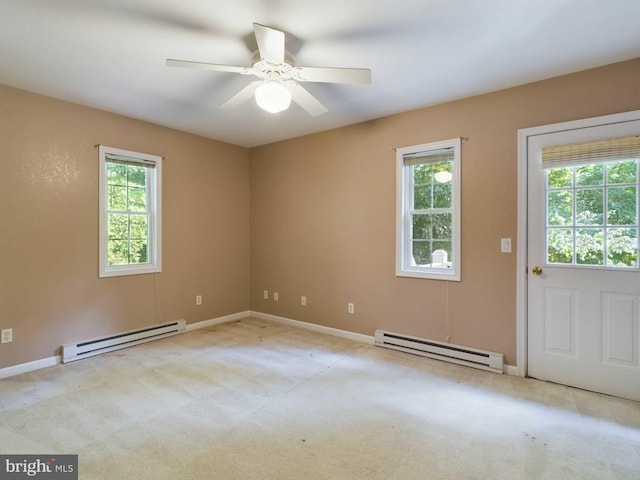 spare room with baseboard heating, a wealth of natural light, and ceiling fan