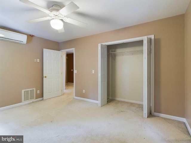 unfurnished bedroom featuring ceiling fan, a closet, light carpet, and a wall mounted AC