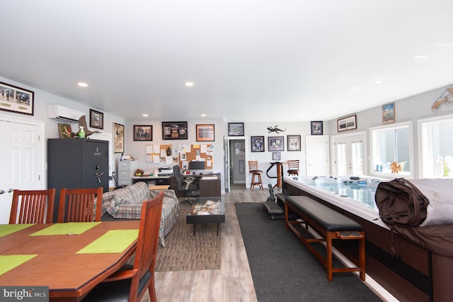 dining area with an AC wall unit and hardwood / wood-style floors