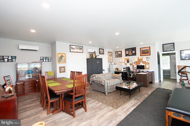 dining room with light wood-type flooring and an AC wall unit