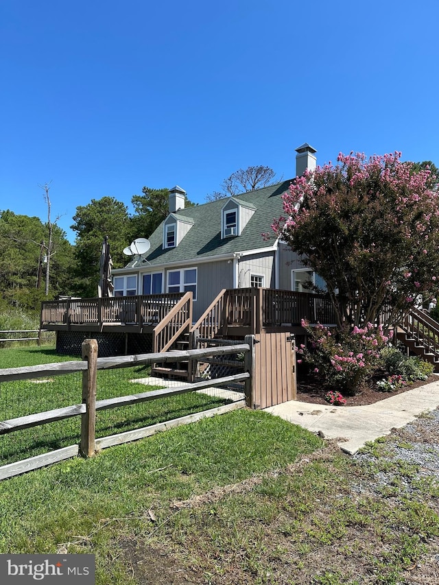 back of property with a wooden deck and a yard