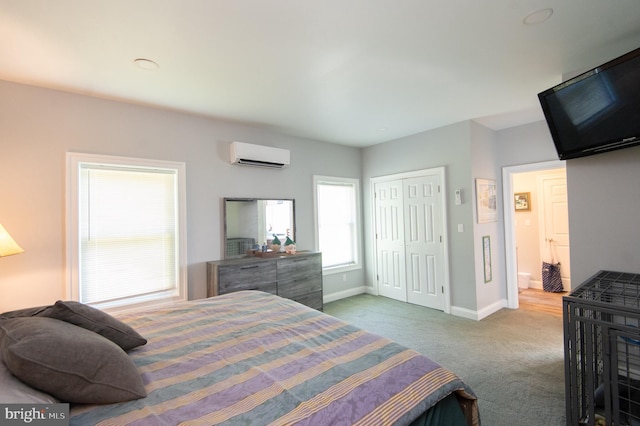 bedroom with a closet, carpet flooring, and a wall unit AC