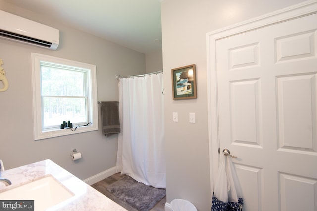 bathroom featuring hardwood / wood-style flooring, an AC wall unit, and sink