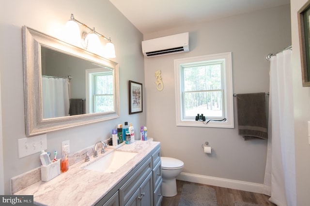 bathroom featuring a wall mounted AC, toilet, plenty of natural light, and vanity