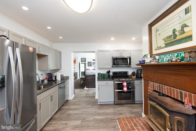 kitchen featuring light wood-type flooring, appliances with stainless steel finishes, crown molding, and sink