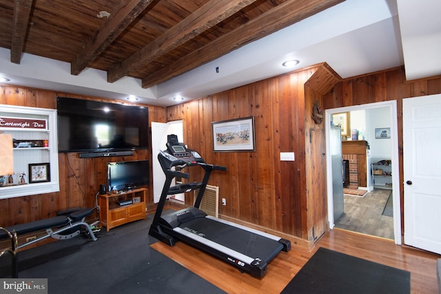 workout area featuring wooden ceiling, wooden walls, dark hardwood / wood-style flooring, and a fireplace