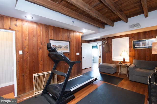 exercise room with wood ceiling, wooden walls, and dark hardwood / wood-style floors