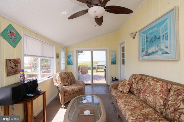 living room with vaulted ceiling, a healthy amount of sunlight, dark colored carpet, and ceiling fan